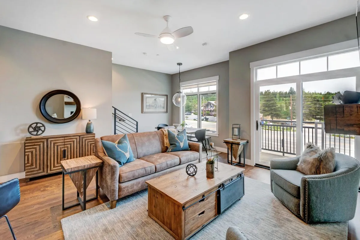 A stylish and cozy living room with a comfortable sofa, modern coffee table, and a large window flooding the area with light. Decorative touches make the space inviting for relaxing, reading, or socializing with family and friends.